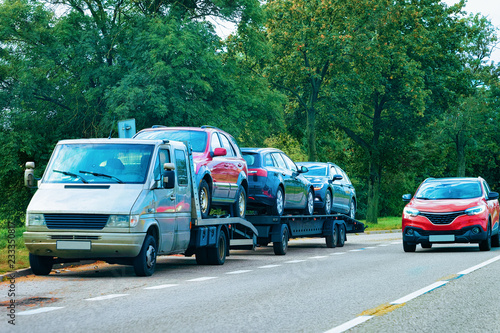 Car carrying trailer with new vehicles on road Slovenia