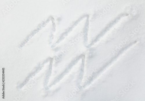 Sign of zodiac Aquarius on white snow © glebchik
