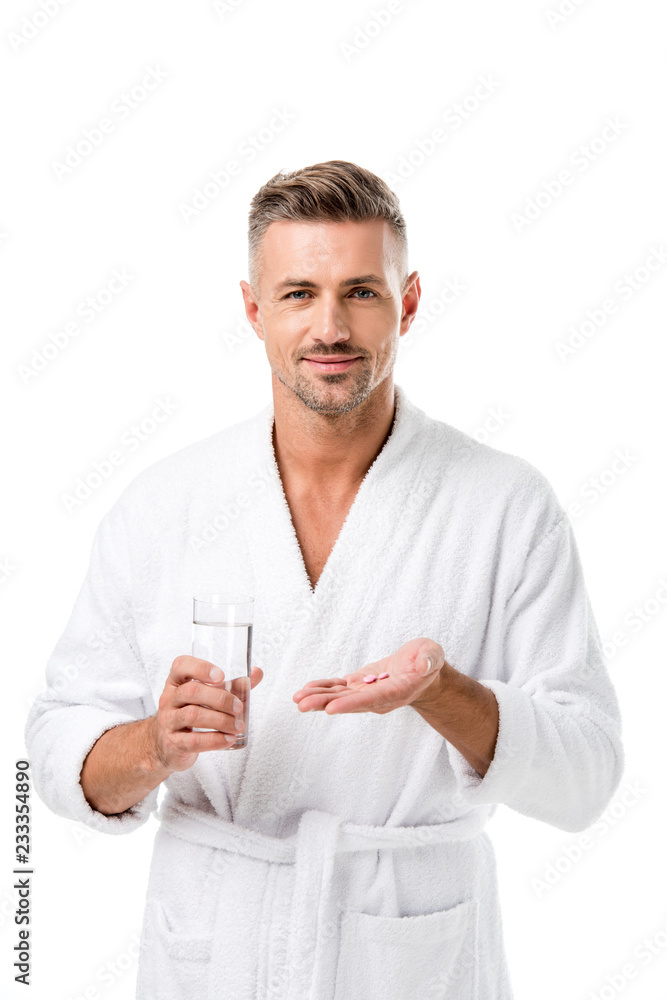 smiling man in bathrobe holding pills and glass of water isolated on white smiling man in bathrobe holding pills and glass of water isolated on white