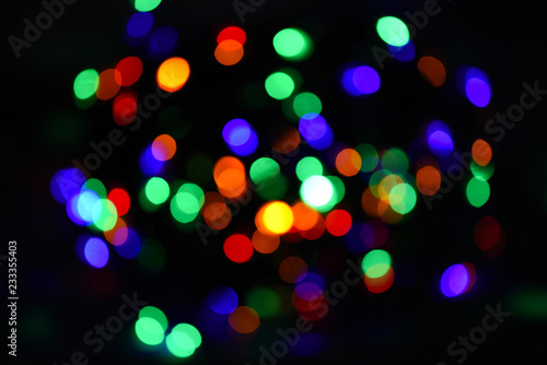 Bright and festive atmosphere of coming holiday. Abstract colorful bokeh background. Christmas decorations concept. Defocused light of colorful garland. Festive backdrop with colorful lights