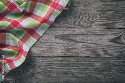 Top view of a multi-colored tablecloth on the left side of a wooden table. Food Background