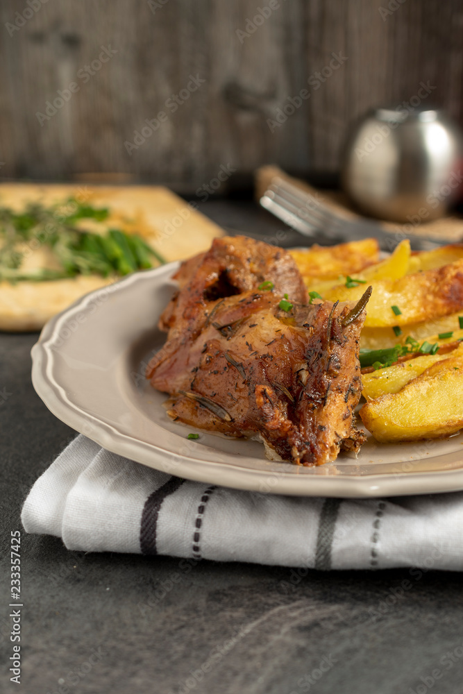 Roast pork with herbs and vegetables on rustic wooden table. Roast pork with herbs and vegetables on rustic wooden table.
