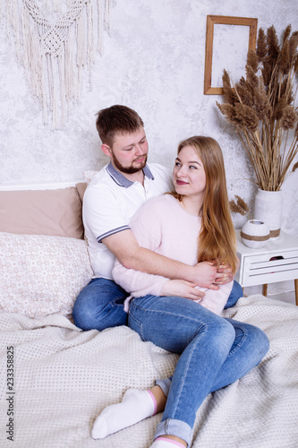 Young couple in love have fun on bed at home