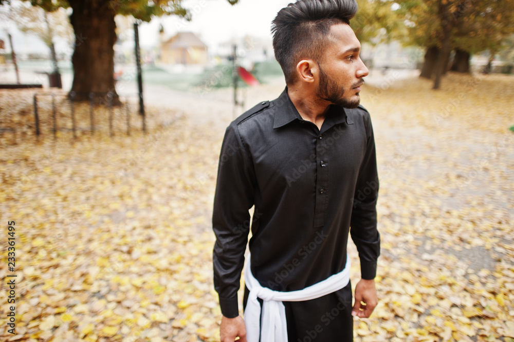 Indian stylish man in black traditional clothes posed outdoor against autumn mood. Indian stylish man in black traditional clothes posed outdoor against autumn mood.