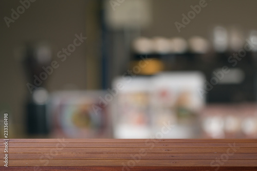 Wooden desk with Blurred of coffe's shop for abstract background