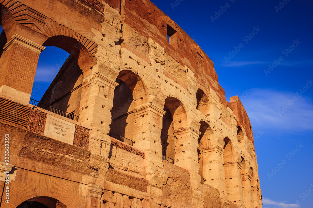 Scenic sunset over the Colosseum. Marble arches ruins over a blue sky, Rome, Italy