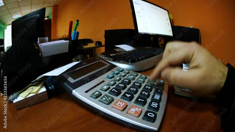 A man counts on a calculator. Efficient office work A man counts on a calculator. Efficient office work