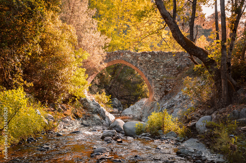 Elia Bridge - ancient stone bridge across a narrow mountain river on rocky banks. Landmark of Cyprus.