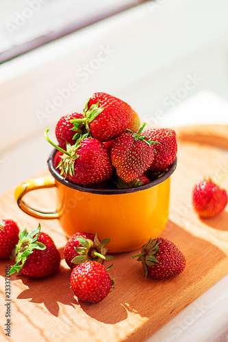 Strawberries in an old retro mug on the windowsill