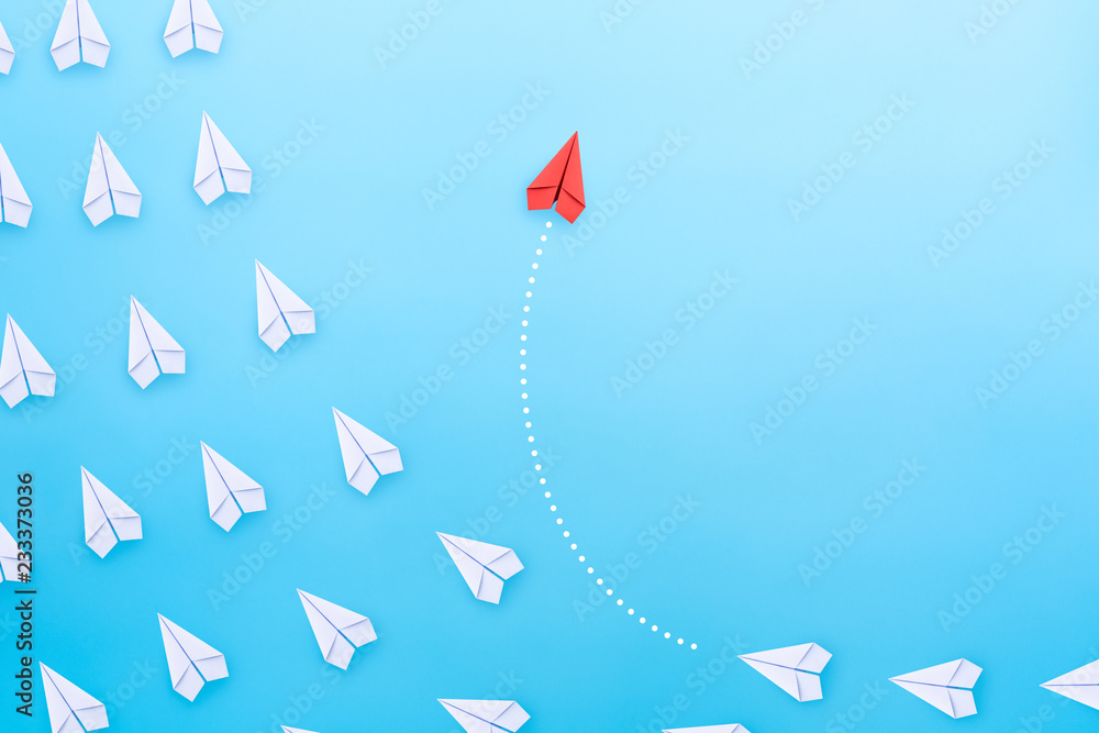 Group of white paper plane in one direction and one red paper plane pointing in different way on blue background. Business concept for new ideas, creativity, innovation and solution. - obrazy, fototapety, plakaty 