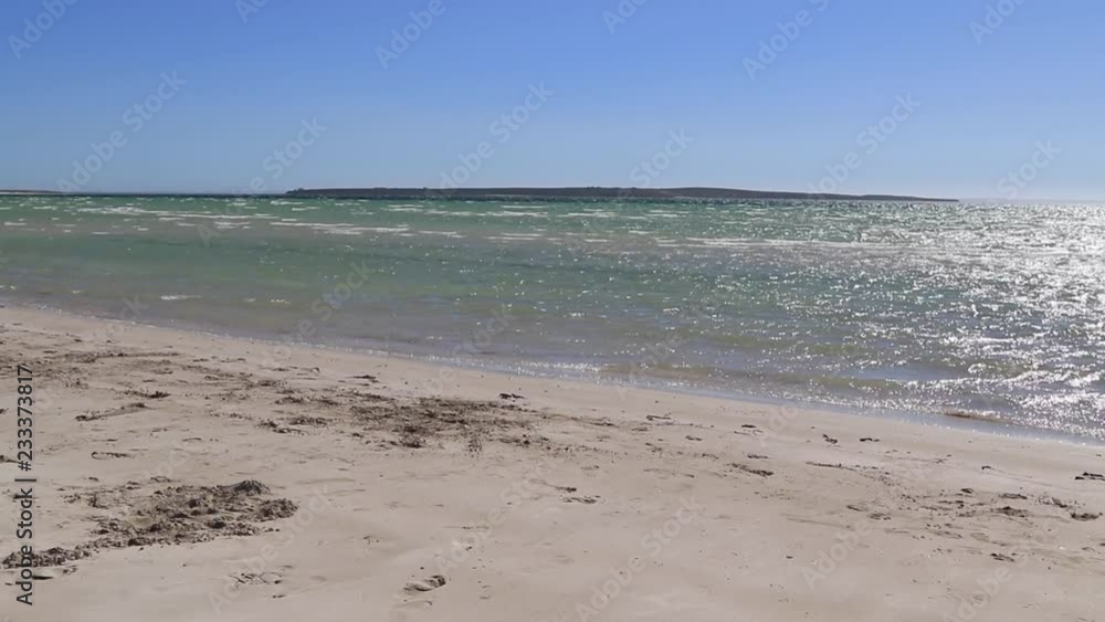 Small waves breaking on sandy beach on windy day at Perlubi Beach, South Australia Small waves breaking on sandy beach on windy day at Perlubi Beach, South Australia