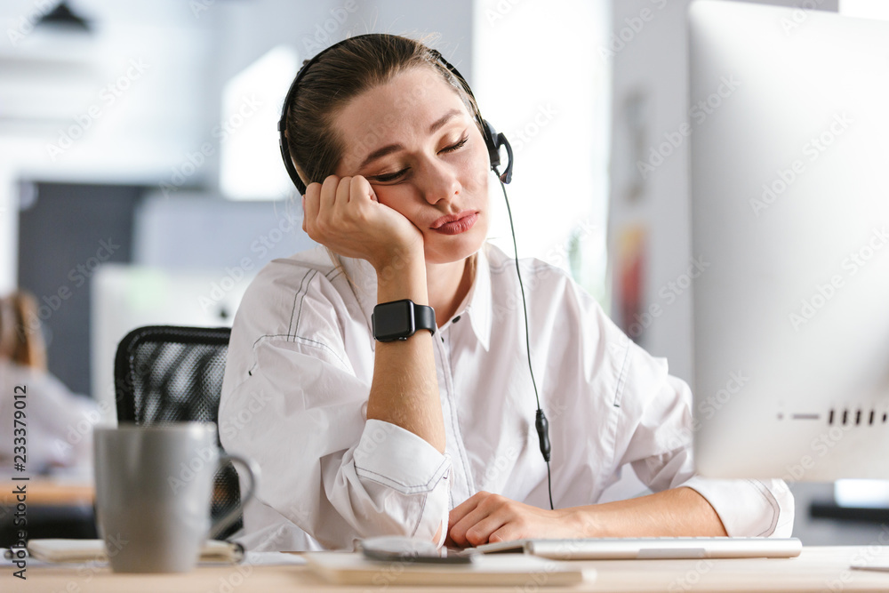 Bored young woman wearing microphone headset Bored young woman wearing microphone headset