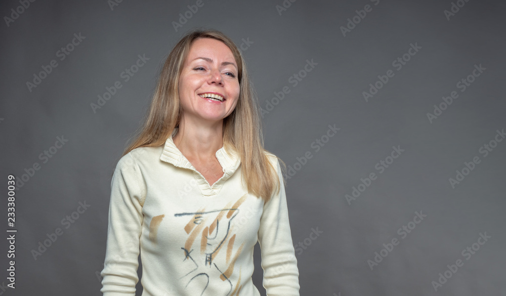 Woman with positive emotion. Attractive blonde is laughs nonchalantly. Portrait of european appealing woman isolated on gray background. Real feelings, languages of bod. Adult girl shooting in studio. Woman with positive emotion. Attractive blonde is laughs nonchalantly. Portrait of european appealing woman isolated on gray background. Real feelings, languages of bod. Adult girl shooting in studio.