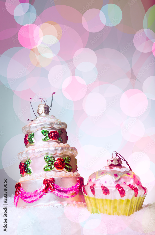 Christmas tree decoration with the shape of a multi floor cake, on snow, against a beautiful holiday inspired background, copy space left Christmas tree decoration with the shape of a multi floor cake, on snow, against a beautiful holiday inspired background, copy space left