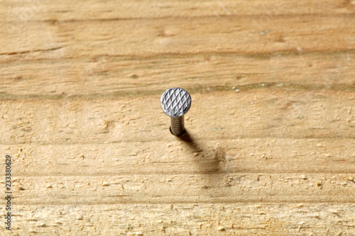 nail fixed in a wooden board