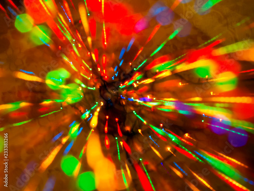 Abstract multicolored festive lights on a red and orange background.