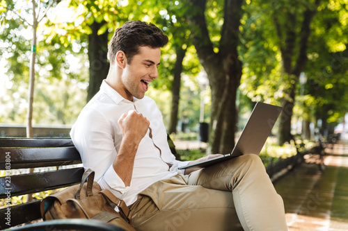 Cheerful young businessman sitting outdoors