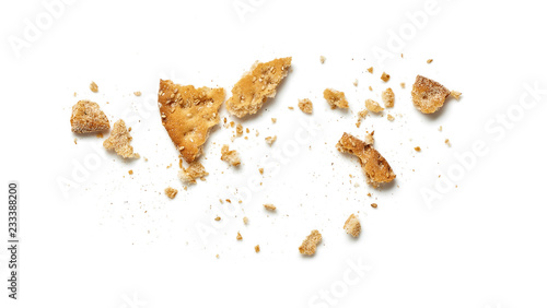 Scattered crumbs of cookie or cracker isolated on white background. Top view. photo