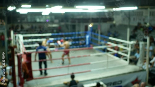 asian men thai boxing are punch and kick together with committee on canvas boxing stadium