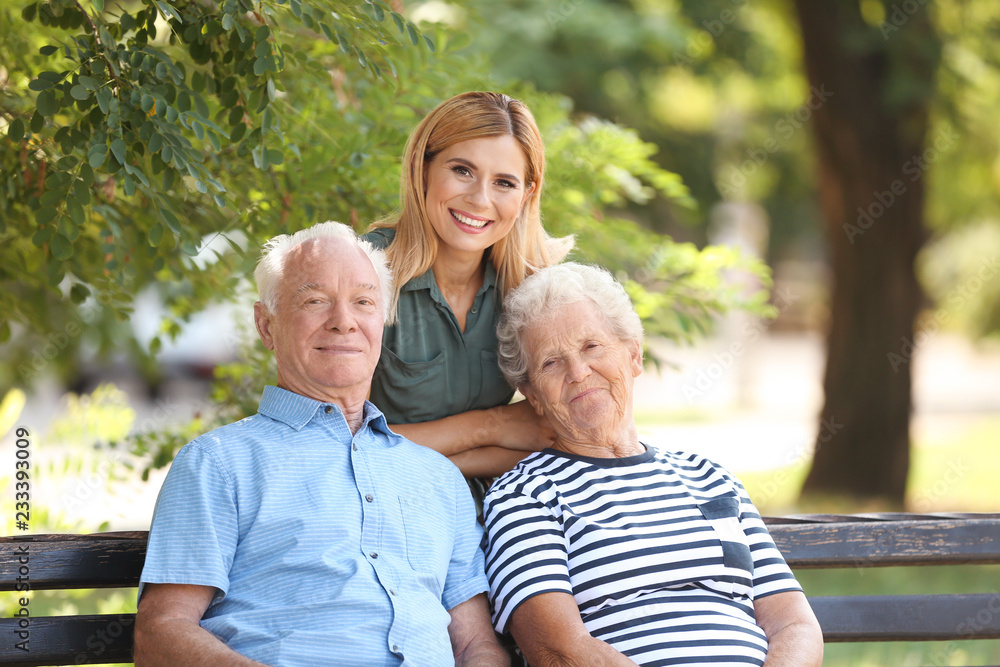 Woman with elderly parents in park on sunny day Woman with elderly parents in park on sunny day