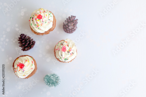 white cupcake over the white background that decorated with gold and silver ribbons 