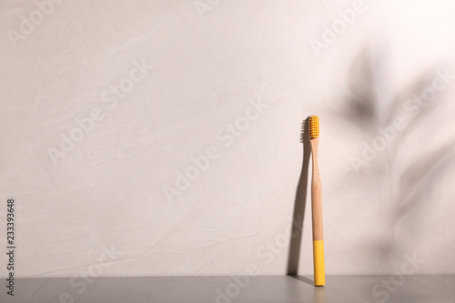 Bamboo toothbrush on table against grey background. Space for text