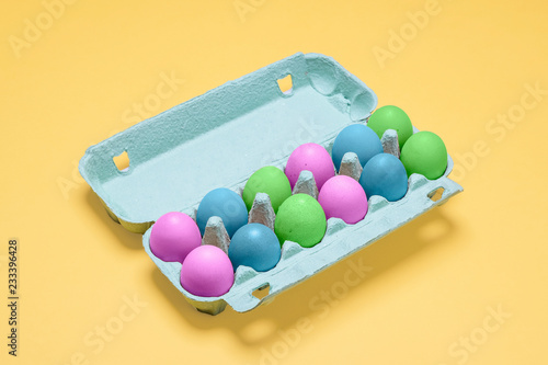 Canvas Print Dozen dyed easter eggs in carton container