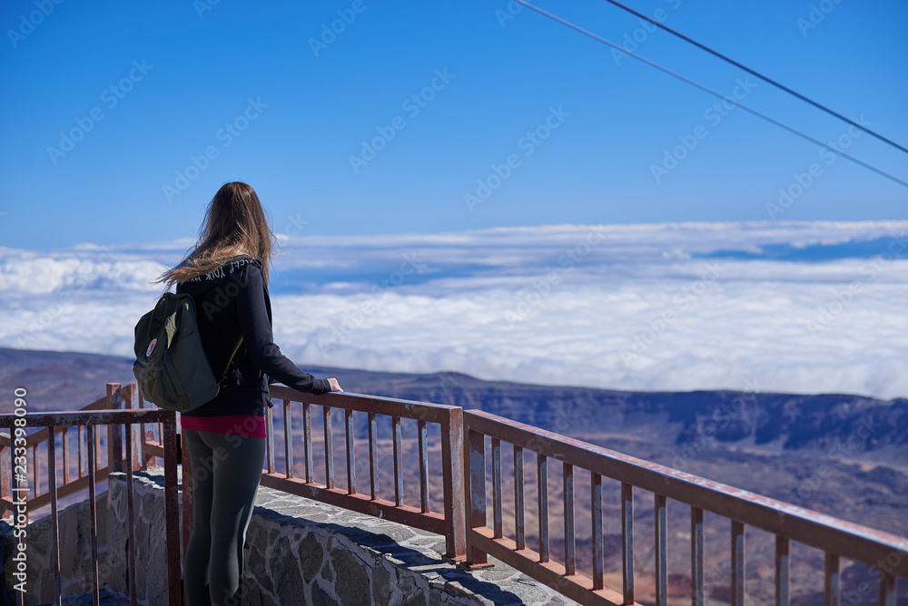 Mujer joven ante el mar de nubes del Teide