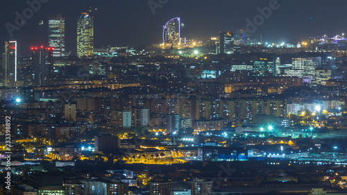 Barcelona and Badalona skyline with roofs of houses and sea on the horizon night timelapse