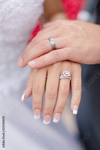 wedding rings on hands of newlyweds