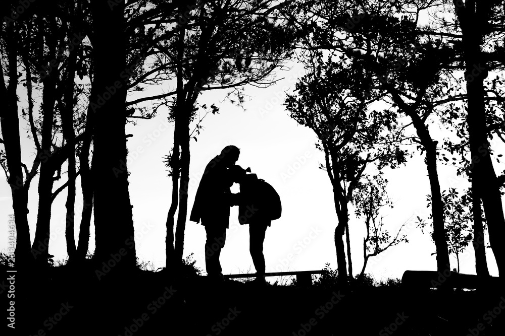 silhouette of love couple in trees border, back and white tone silhouette of love couple in trees border, back and white tone