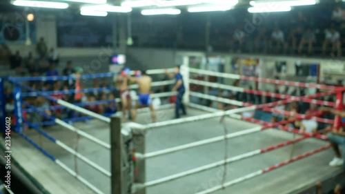 asian men thai boxing are punch and kick together with committee on canvas boxing stadium