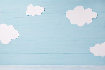 Cute children or baby card, white clouds on the blue wooden background