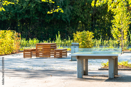 Moderne Holzbank Sitzmöglichkeit im Park. Beton Tischtennisplate