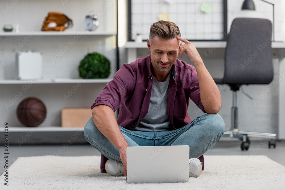 handsome man sitting in home office and working on laptop handsome man sitting in home office and working on laptop