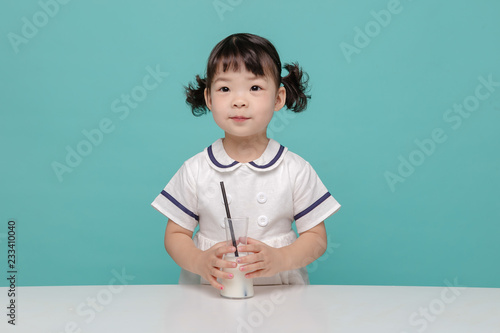 Little pretty Asian girl laughing portrait with milk and bread, healthy and happy lifestyle.