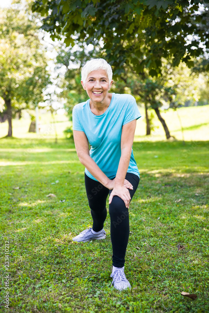 Senior woman doing streching exercise in the park Senior woman doing streching exercise in the park