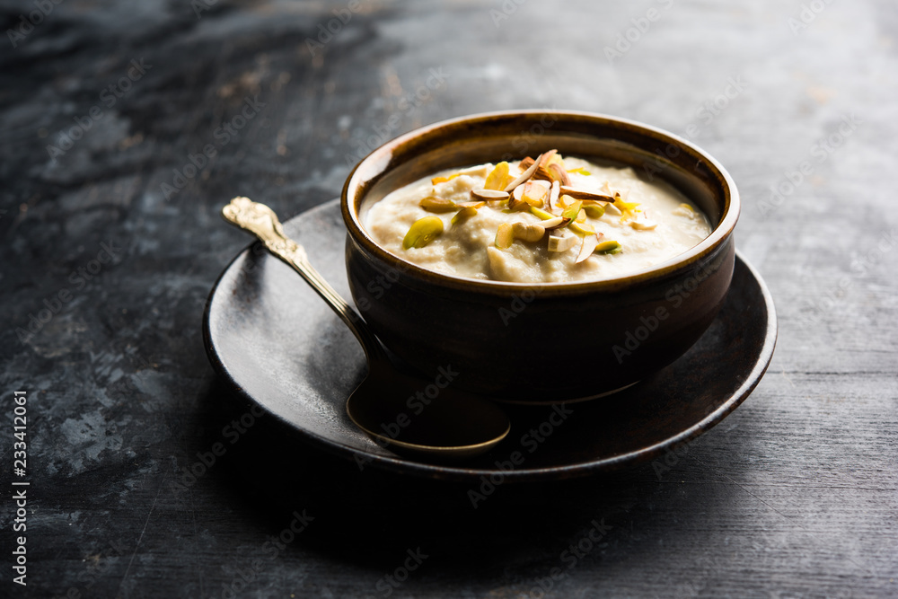 Sweet Rabdi or Lachha Rabri or basundi, made with pure milk garnished with dry fruits. Served in a bowl over moody background. Selective focus Sweet Rabdi or Lachha Rabri or basundi, made with pure milk garnished with dry fruits. Served in a bowl over moody background. Selective focus
