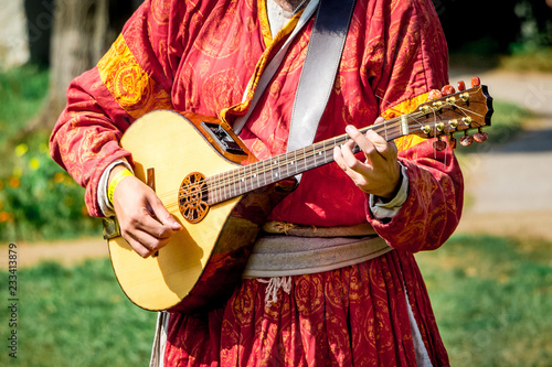 Photos Musician in medieval bright clothes plays on lute