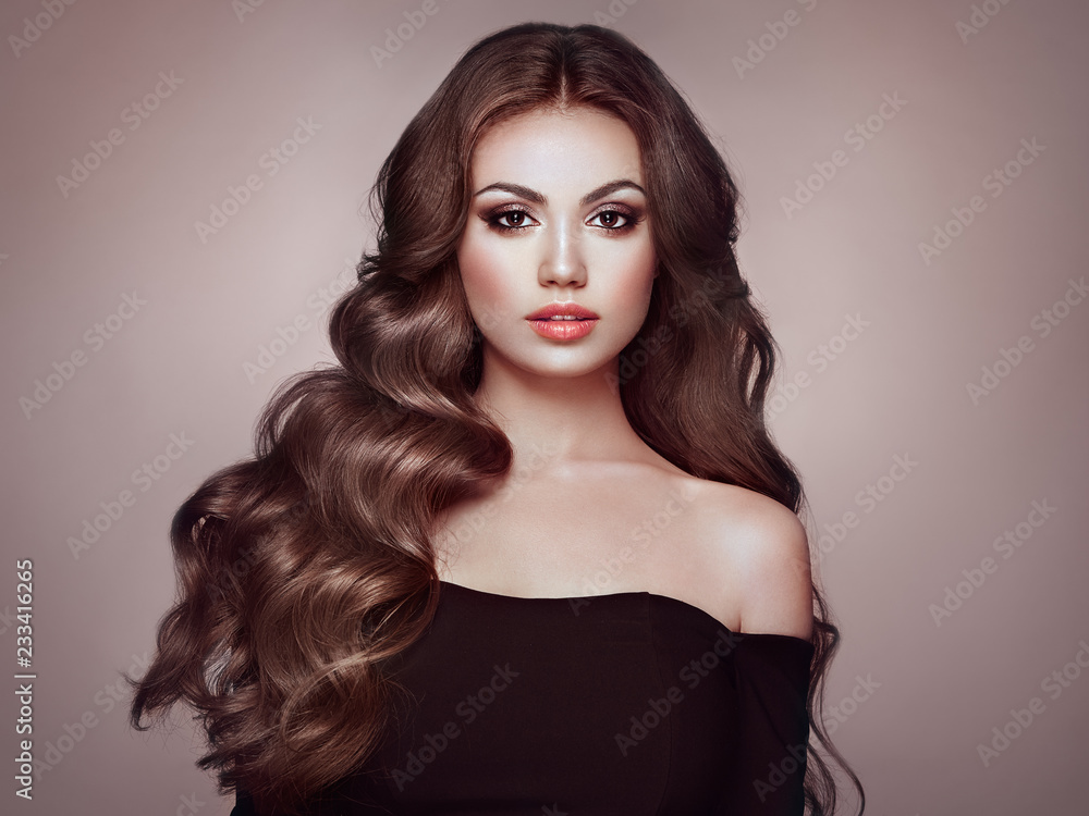 Brunette Girl with Long Healthy and Shiny Curly Hair. Care and Beauty. Beautiful Model Woman with Wavy Hairstyle. Make-Up and Black Dress Brunette Girl with Long Healthy and Shiny Curly Hair. Care and Beauty. Beautiful Model Woman with Wavy Hairstyle. Make-Up and Black Dress