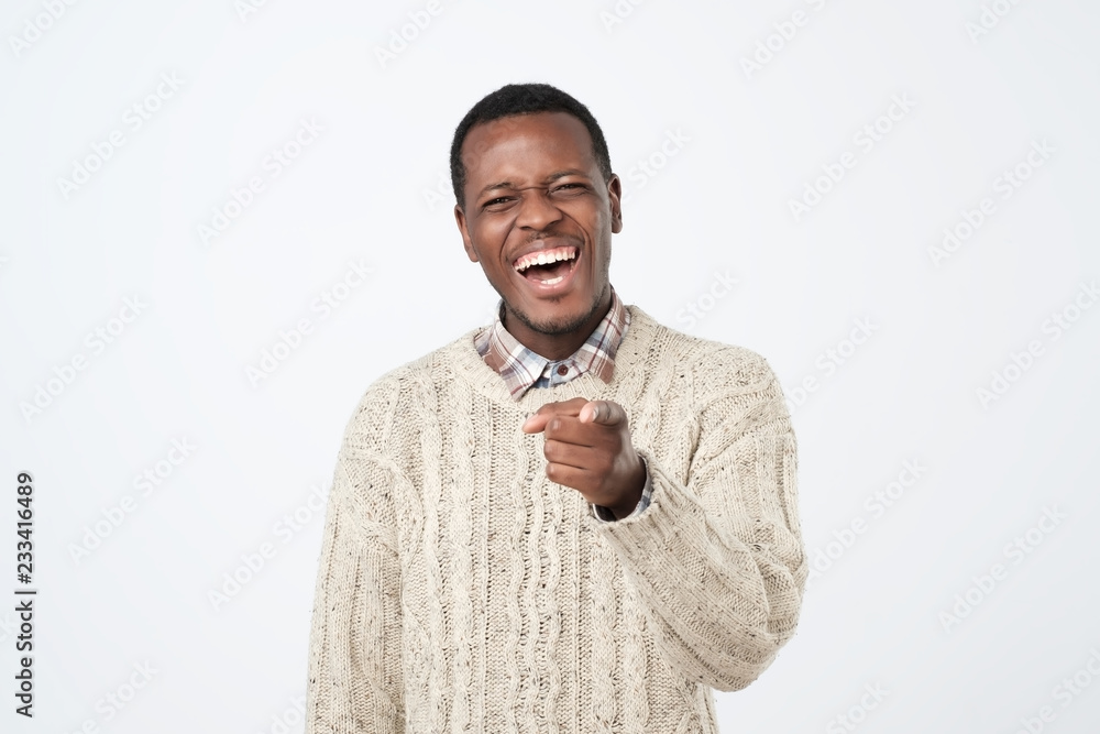 Handsome african man laughing out loud at funny meme or joke he found on  internet, smiling broadly. Stock Photo | Adobe Stock
