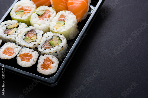Japanese food: maki and nigiri sushi set on black background. Copyspace