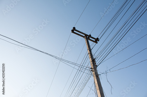 Power pole with power lines on blue sky background