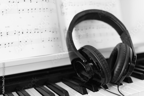 Close up of headphone on a piano with music note in the background photo