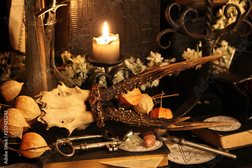 Black candle Magic Ritual. Antique Magic Book. Witchcraft  Peacock feathers and candle background.
