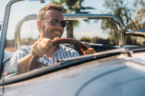 Man driving a convertible vintage car