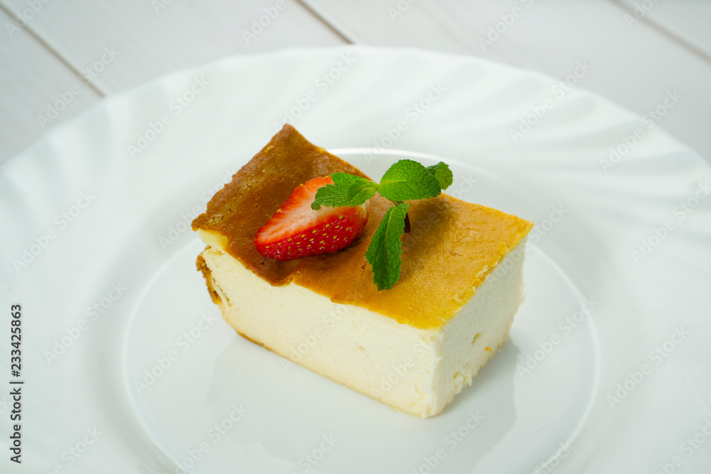 Casserole and strawberry with mint on a white plate