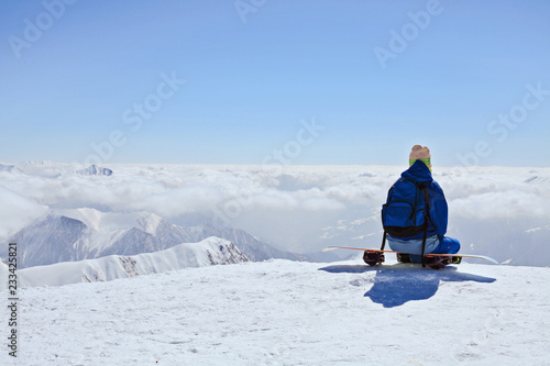 snow border sit on the top of the hill on his board  in nice sunny day. Caucasus Mountains in winter, Georgia, region Gudauri, Mount Kudebi. photo