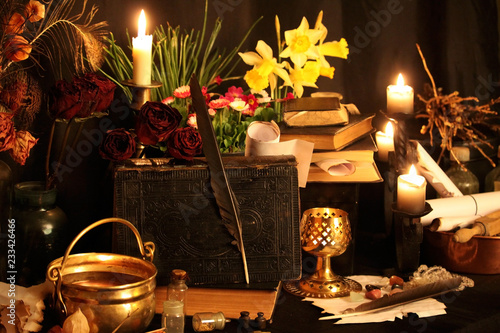 Antique Magic Book. Witchcraft Peacock feathers and candle background. Black candle Magic Ritual.