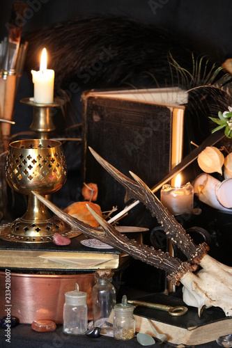 Black candle Magic Ritual. Antique Magic Book. Witchcraft  Peacock feathers and candle background.